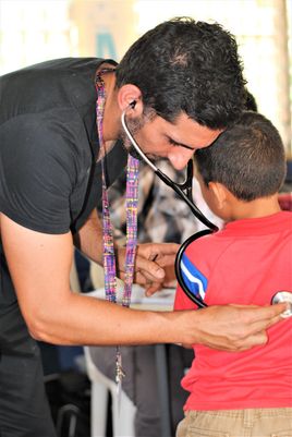 Doctor Aman listening to a child's lungs