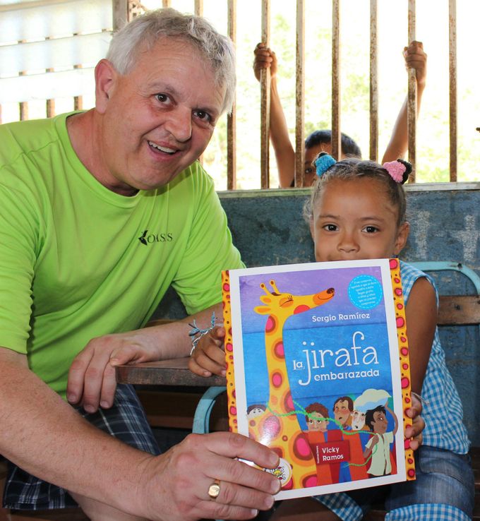 Social Worker Maurice presenting a book to one of the children.