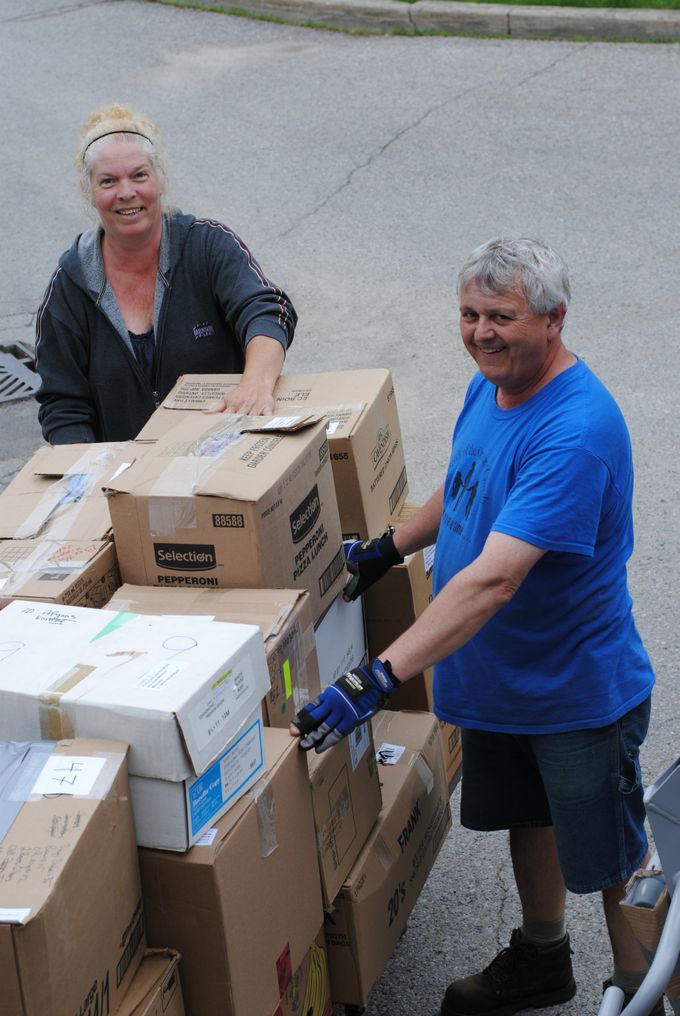 Mary Shean and Maurice Voisin help load the many boxes onto the 40 foot container.